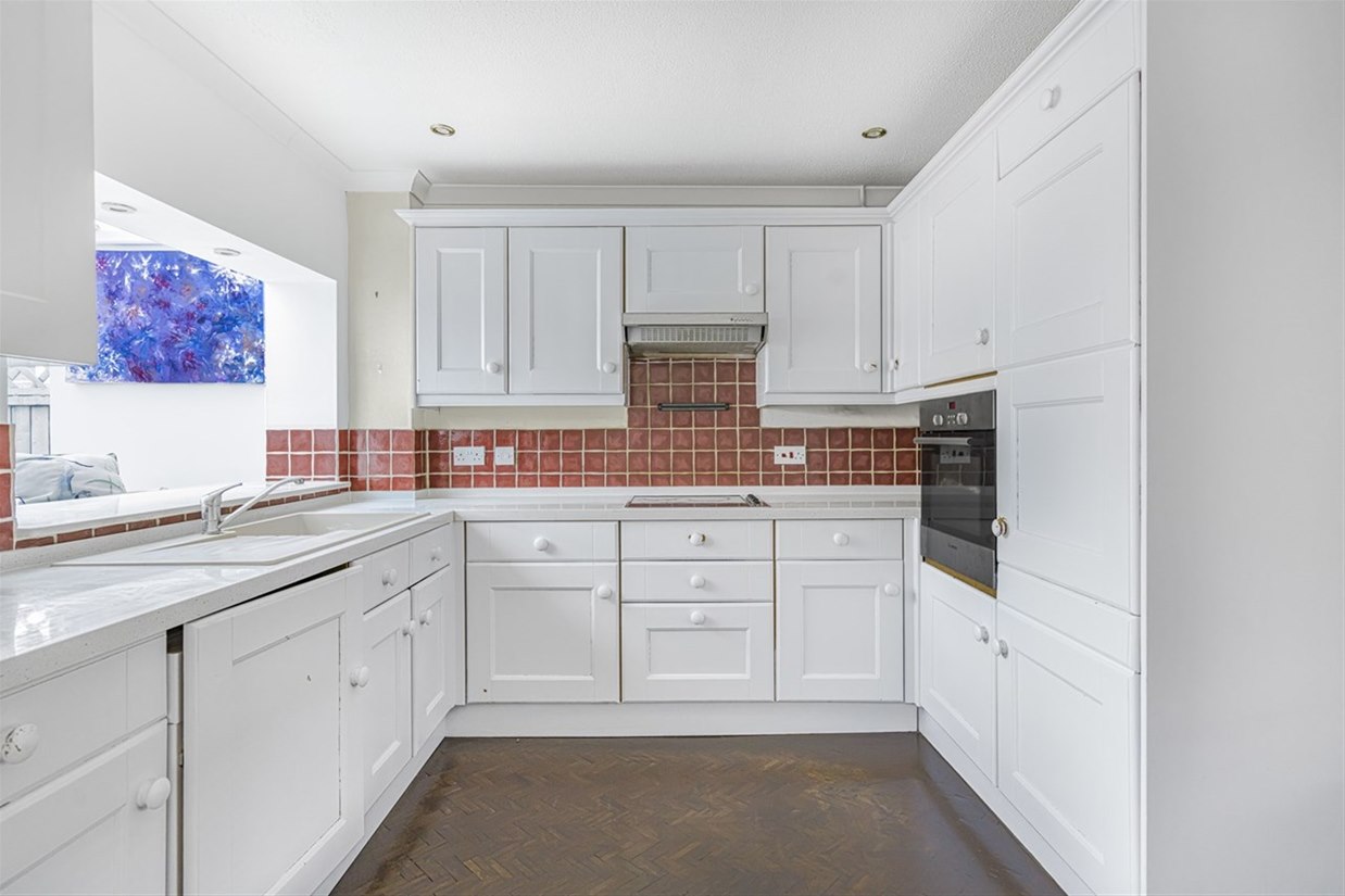 Fitted kitchen with integrated oven