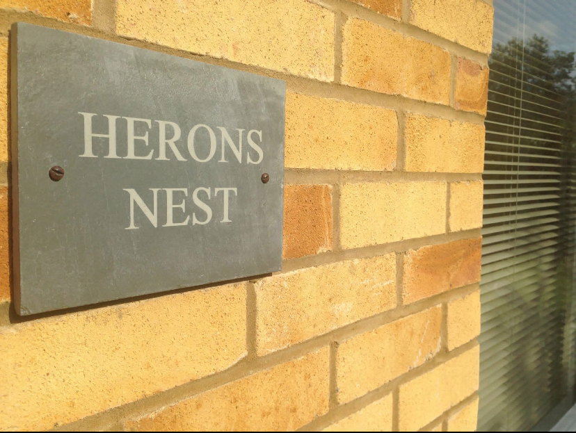 The slate 'Herons Nest' plaque beside the annex entrance